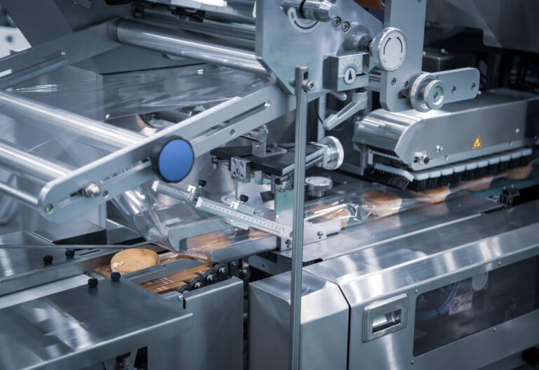 Automatic packing of bakery product flow pillow packing machine. Bread, toast, bun plastic wrapping machine on bakery production line